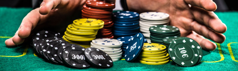 man's hands pushing all his chips in at a poker table.