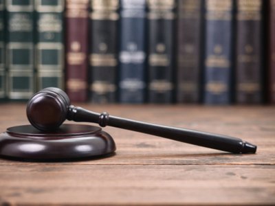 a gavel on a table with law library books in the background